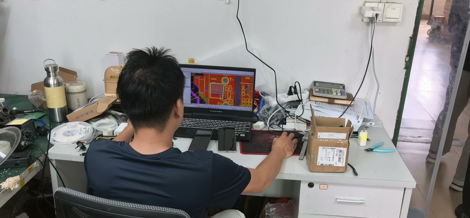 Engineer working on a PCB design at a workstation